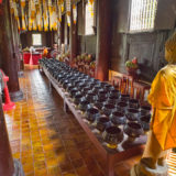 Buddhist monk with rows of bowls